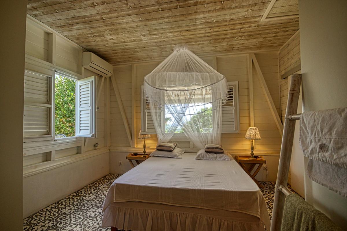 17 Location villa Martinique- Chambre lit fenêtre extérieur